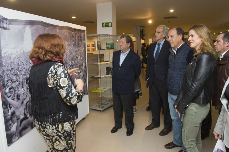 Cristina Cuesta explicando la exposición "EN PIE DE FOTO" y al fondo, los libros donados por la FMAB.